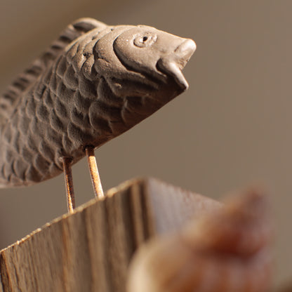 Keramikfisch auf Holz
